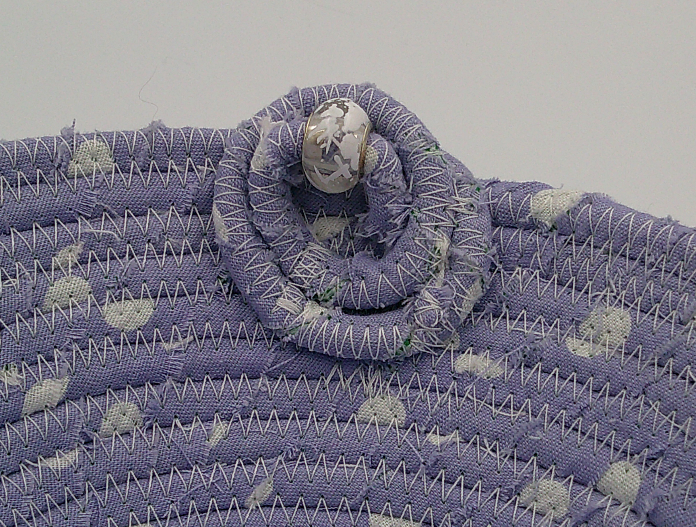 This shows a closeup of the circles with the bead. It also shows some of the frayed raw edges of the fabric adding to its charm. This shows a closeup of the circles with the bead. It also shows some of the frayed raw edges of the fabric adding to its charm.